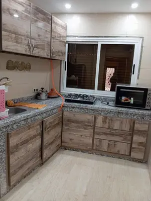 a kitchen with a counter with a microwave and a window at Quiet and central apartment in Oulad Akkou