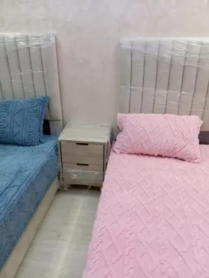 a bedroom with two beds and a night stand at Quiet and central apartment in Oulad Akkou