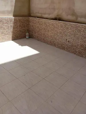 an empty room with a tile floor and a brick wall at Quiet and central apartment in Oulad Akkou