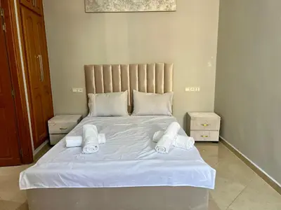 a bed with white sheets and towels on it at Prestige Apartment - Fes Elegant Stay in Fès