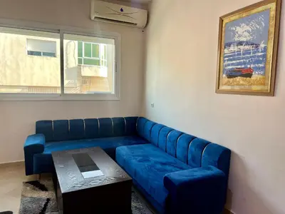 a living room with a blue couch and a table at Prestige Apartment - Fes Elegant Stay in Fès