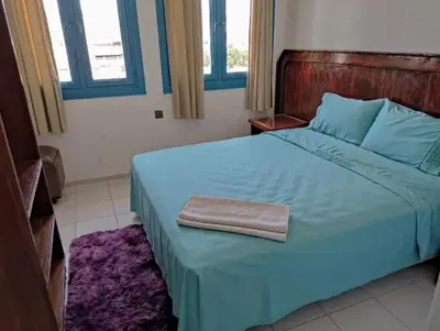 a bedroom with a blue bed with a towel on it at Afriquia Star in Oulad Akkou