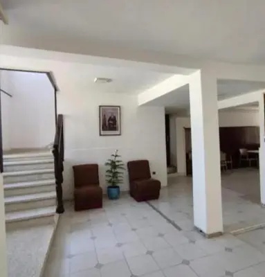 a living room with two chairs and a staircase at Afriquia Star in Oulad Akkou