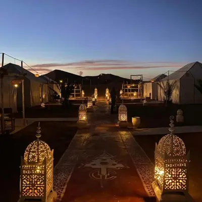 a group of tents with lights at night at Merzouga Stars Camp in Merzouga