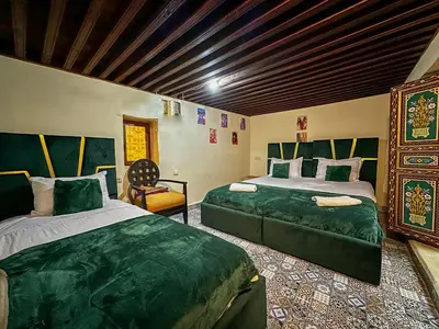 a bedroom with two beds and a chair in it at Riad Sufi House Fes in Fès