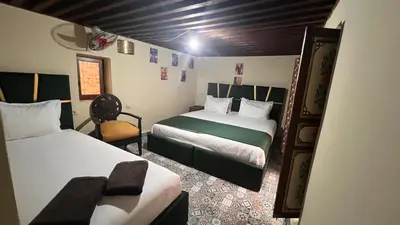a small room with two beds and a chair at Riad Sufi House Fes in Fès