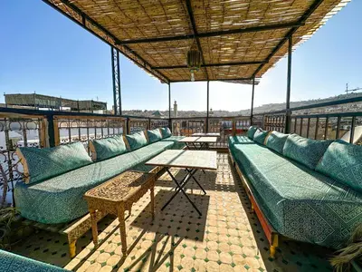 a patio with couches and tables on a roof at Riad Sufi House Fes in Fès