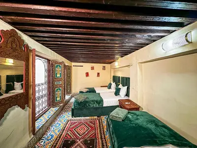 a large room with two beds and a window at Riad Sufi House Fes in Fès