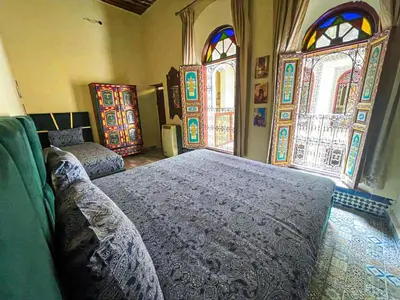 a bedroom with two beds and stained glass windows at Riad Sufi House Fes in Fès