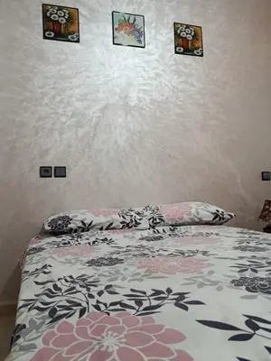 a bed in a bedroom with pictures on the wall at Dar araha in Fès