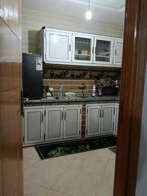 a kitchen with white cabinets and a black refrigerator at Dar araha in Fès