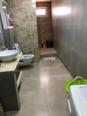 a bathroom with two sinks and a toilet and a shower at essaouira appartement borito in Oulad Akkou