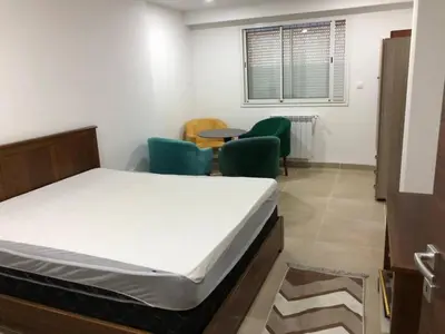 a room with a bed and chairs and a table at essaouira appartement borito in Oulad Akkou