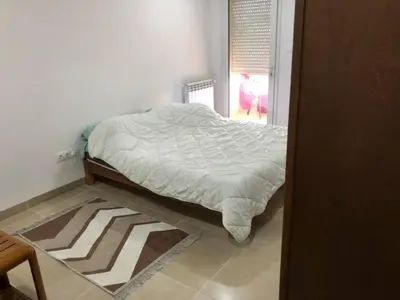 a bed sitting in a room with a window at essaouira appartement borito in Oulad Akkou