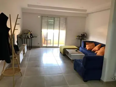 a living room with a blue couch and a table at essaouira appartement borito in Oulad Akkou