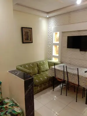 a living room with a green couch and a table at إقامة النور الصخيرات in Oulad Akkou