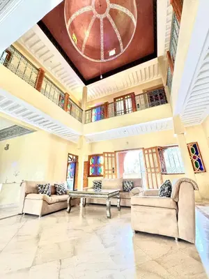 a large living room with couches and a table at Villa H in Oulad Snaguia