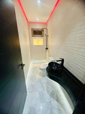 a bathroom with a toilet and a black sink at Villa Itran Marrakech in Aguelmous