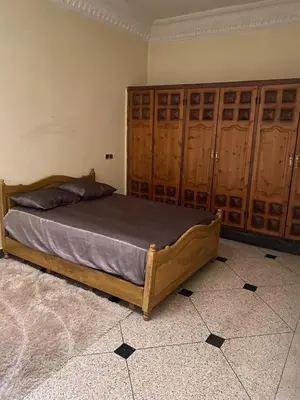 a bedroom with a wooden bed with wooden cabinets at Azrou in Azrou