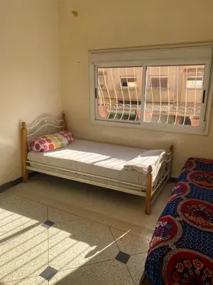 a bed sitting in a room with a window at Azrou in Azrou