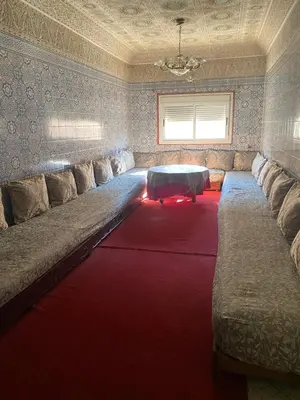 a large couch in a living room with a red carpet at Azrou in Azrou