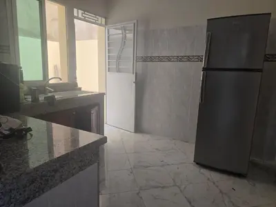 a kitchen with a refrigerator and a tile floor at belle vue à petit prix in Meknès