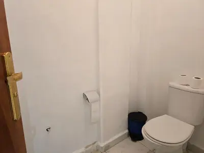 a white bathroom with a toilet and a roll of toilet paper at belle vue à petit prix in Meknès