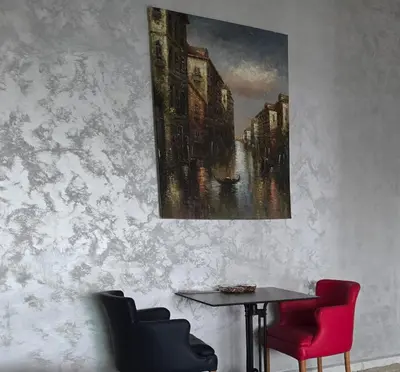 a table with two chairs and a painting on a wall at belle vue à petit prix in Meknès