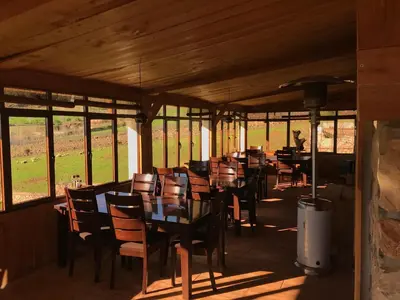 a dining room with tables and chairs and windows at Rise In Valley in Ifrane