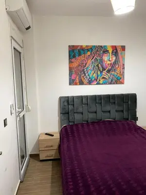 a bed in a room with a painting on the wall at Dar Tranquila in Fès