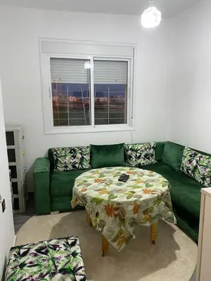 a living room with a green couch and a table at Dar Tranquila in Fès