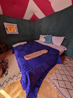 a bedroom with a bed in a tent at Luxury Desert Camp with AC & Heating in Merzouga in Lac Yasmins