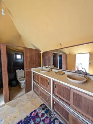 a bathroom with two sinks and a toilet at Luxury Desert Camp with AC & Heating in Merzouga in Lac Yasmins