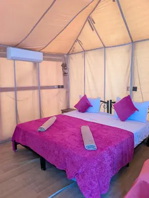 a bedroom with a large bed in a tent at Luxury Desert Camp with AC & Heating in Merzouga in Lac Yasmins
