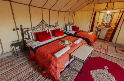 a bedroom with two beds in a tent at Fatima Luxury desert camp in Merzouga