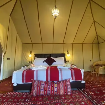 a bedroom with a bed in a tent at Fatima Luxury desert camp in Merzouga