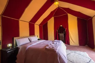 a room with a bed in a tent at Fatima Luxury desert camp in Merzouga