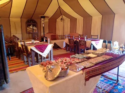 a table with food on it in a tent at Fatima Luxury desert camp in Merzouga