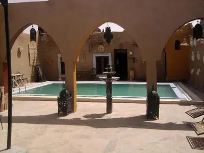 a swimming pool with a fountain in a building at Fatima Luxury desert camp in Merzouga