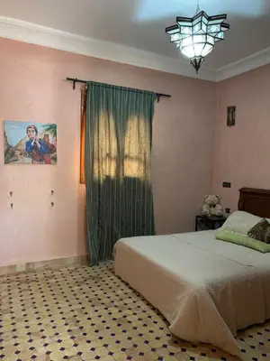 a bedroom with a bed with a window and a chandelier at Villa d'Exception à Ourika Nichée au Cœur des Montagnes in Aghbalou