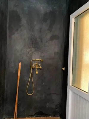 a shower in a bathroom with a black wall at Villa d'Exception à Ourika Nichée au Cœur des Montagnes in Aghbalou