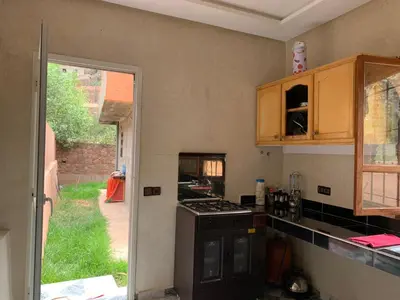 a kitchen with a stove and a door to a yard at Villa d'Exception à Ourika Nichée au Cœur des Montagnes in Aghbalou