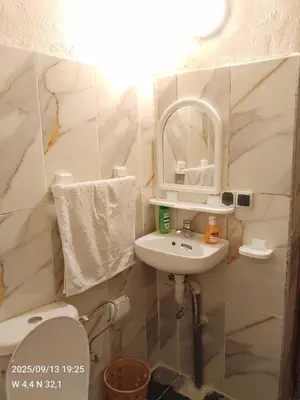 a bathroom with a sink and a toilet and a mirror at Gîte Palma Eagle Ziz Canyon in Er Rachidia