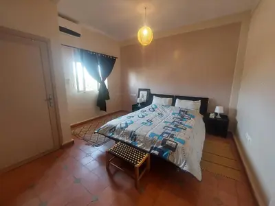 a bedroom with a large bed and a window at Villa sur ferme, piscine & vue sur Atlas in Douar Tounsi