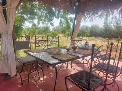 a table and chairs sitting under a tent at Villa sur ferme, piscine & vue sur Atlas in Douar Tounsi