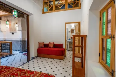 a bedroom with a red couch in a room at Riad Dar Sira in Fès