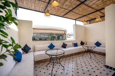a living room with a couch and two tables at Riad Dar Sira in Fès
