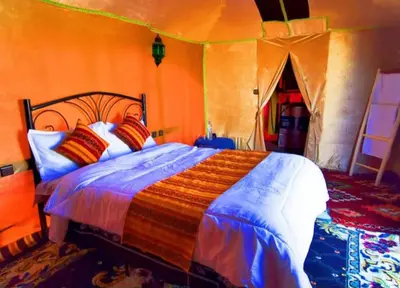 a bedroom with a large bed in a tent at Luxury Sahara Gold Camp in Merzouga
