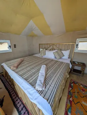 a bedroom with a large bed in a tent at Air Conditioning Berber Desert Camp in Merzouga