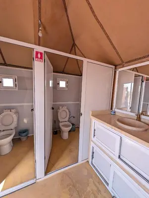 a bathroom with two toilets and a sink at Air Conditioning Berber Desert Camp in Merzouga